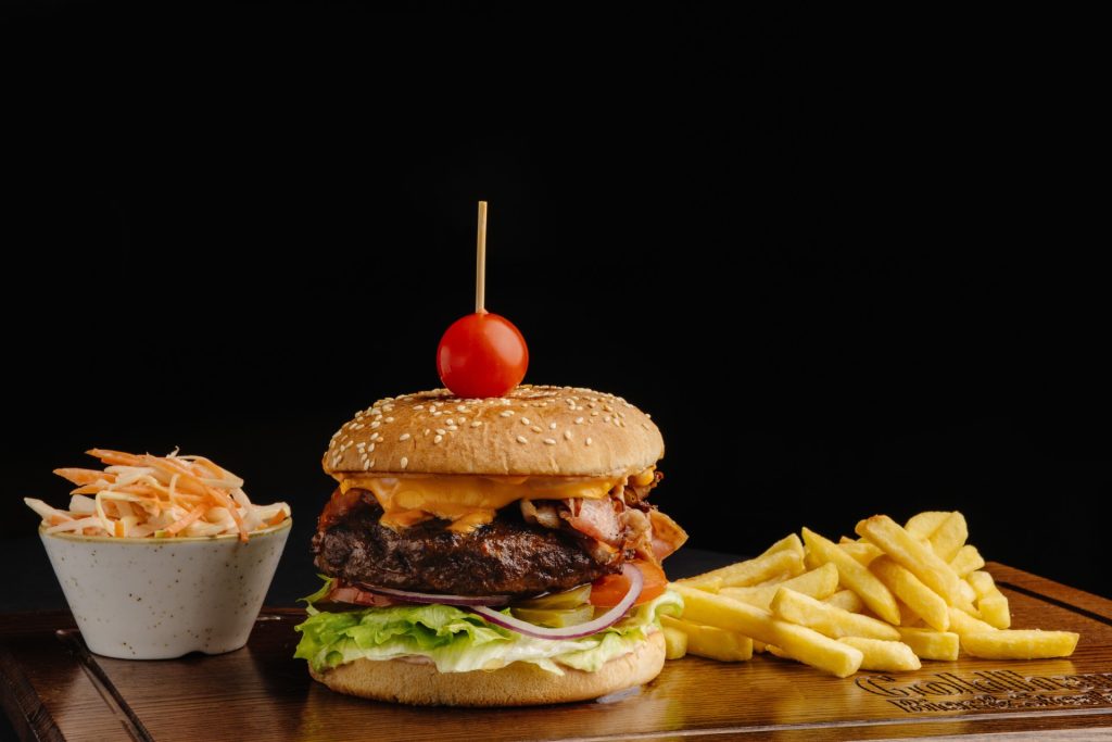 Hamburger cu cașcaval, bacon, salată coleslaw și cartofi prăjiți